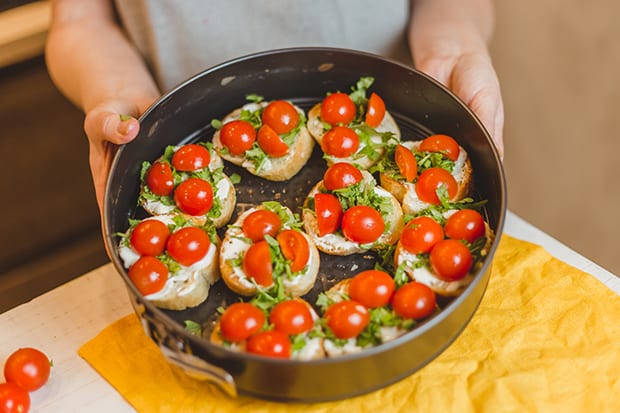 кусочки багета с помидорами и рукколой в форме