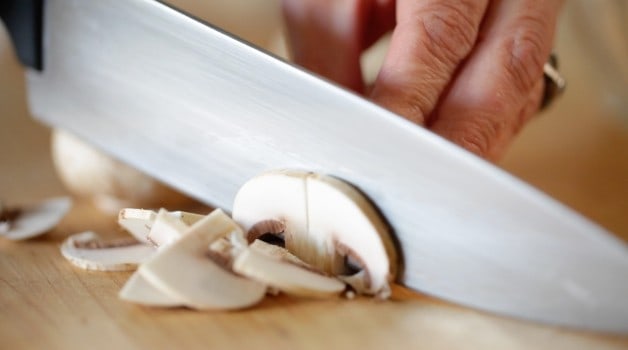 slicing mushrooms on a cutting board