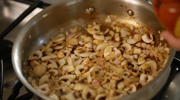 cooking mushrooms and shallots in a skillet