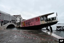A stranded ferry boat lies on its side, in Venice, Wednesday, Nov. 13, 2019.