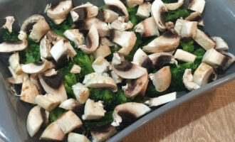Шаг 2: Нарежьте грибы. Выложите в посуду для запекания брокколи и грибы.
