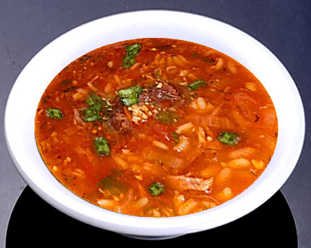 Суп харчо с томатным соусом в тарелке