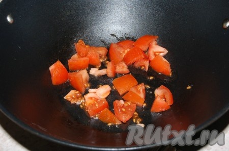 В вок (или в обычную кастрюлю) налить немного растительного масла и положить мелко  нарезанные свежие помидоры.