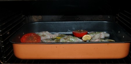 Отправить противень (форму) с рыбой и помидорами в заранее нагретую до 200 градусов духовку на 30 минут.
