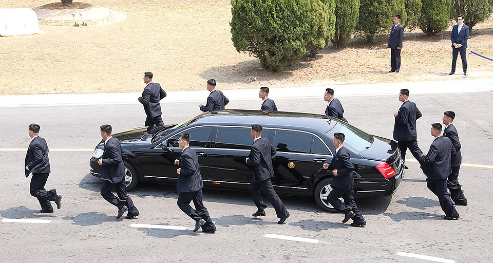 За Ким Чен Ыном неотрывно следовала внушительная армия охранников. На фото они бегом сопровождают его лимузин. Фото: REUTERS
