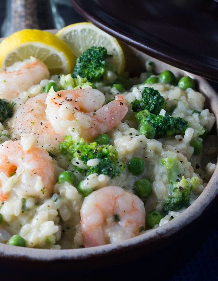 A close up of Easy Lemon Shrimp Risotto in a bowl with lemon slices