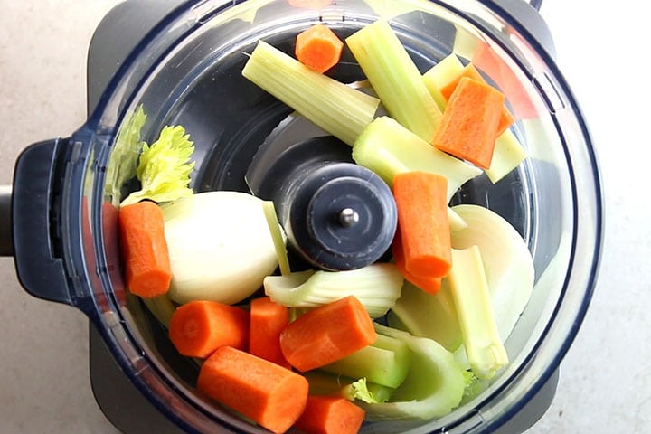 The onion carrot and celery in a food processor ready to chop