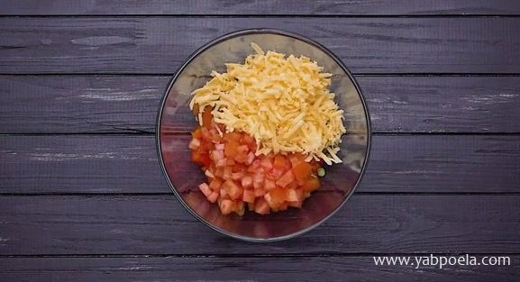 Туда же добавьте мелко нарезанный помидор, натертый на терке твердый сыр, пропущенный через пресс 2 зуб. чеснока, треть соли.